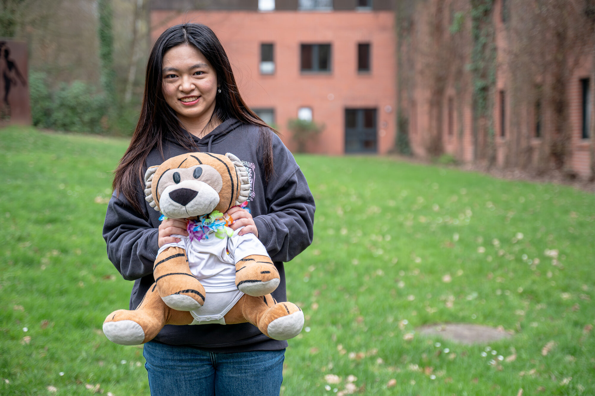 Einzelfoto von Teilnehmerin Dora Yang mit Maskottchen auf dem Arm