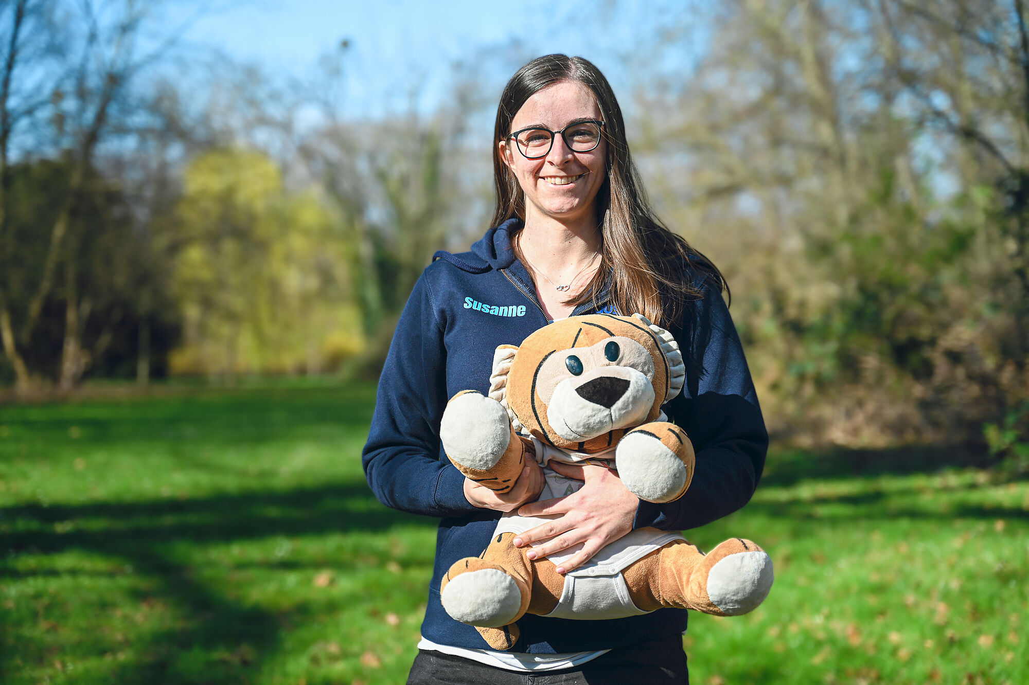 Susanne Armbruster mit MathemaTigerin und EGMO-Pullover im Grünen. 