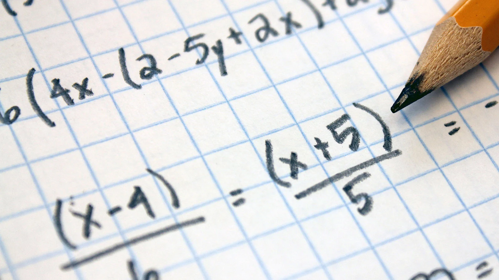 Mathematische Formeln auf kariertem Papier mit einem Bleistift.